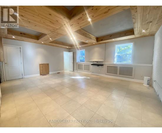A spacious room with wooden ceiling and tiled floor.
