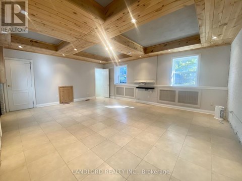 A spacious room with wooden ceiling and tiled floor.