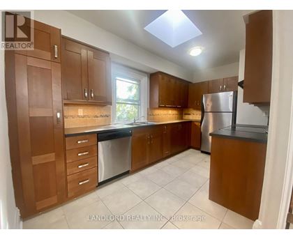A kitchen with brown cabinets and a refrigerator.