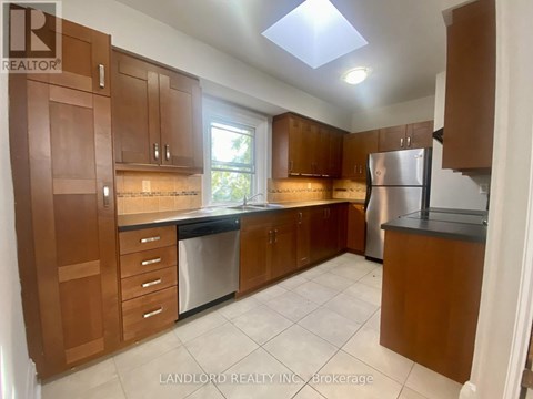 A kitchen with brown cabinets and a refrigerator.