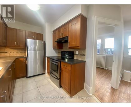 A kitchen with wooden cabinets and a stainless steel refrigerator.