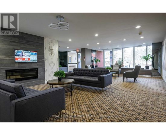 A living room with a fireplace and a television on the wall.