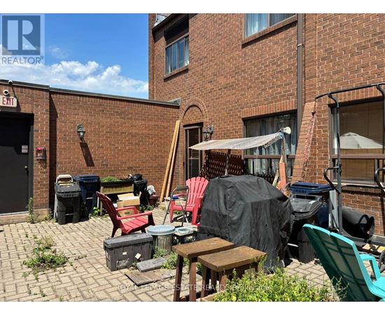 A patio with a table and chairs is covered with a black tarp.