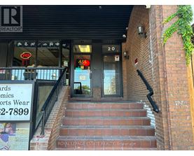 A building with a sign that says "Royal LePage Estate Realty, Brokerage" on the stairs.