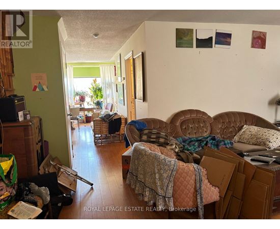 A living room with a couch, a chair, and a pile of boxes on the floor.