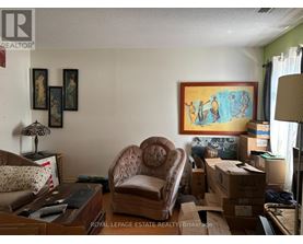 A room with a brown chair and boxes on the floor.