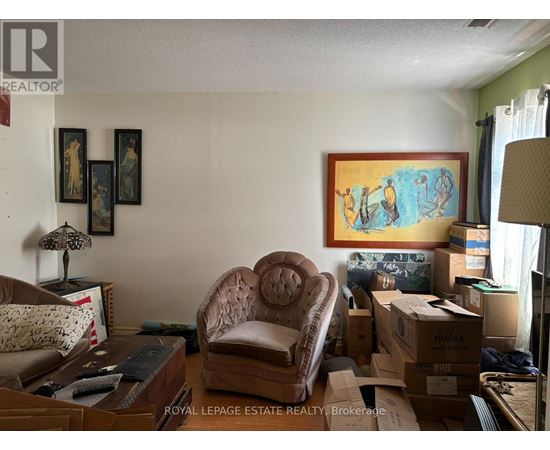 A room with a brown chair and boxes on the floor.
