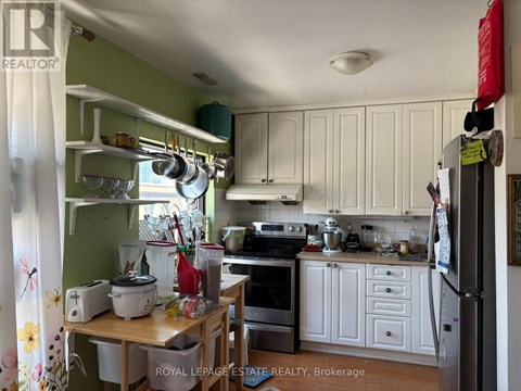 A kitchen with white cabinets and a green wall.