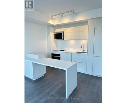 A modern kitchen with white cabinets and a white island.