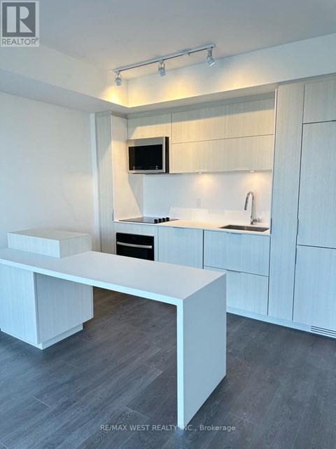 A modern kitchen with white cabinets and a white island.