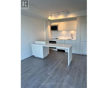 A white kitchen with a table and a microwave above it.