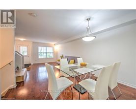 A dining room with a glass table and white chairs.