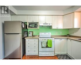 A kitchen with white cabinets and green walls.