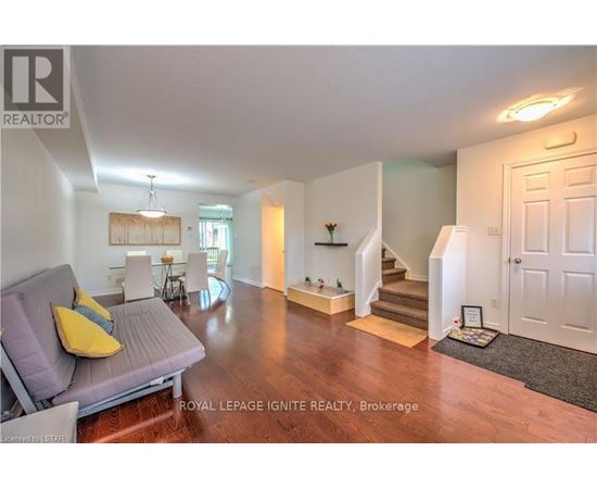 A living room with a grey couch and a yellow pillow.