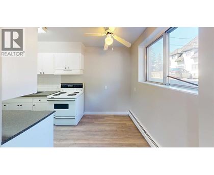 A kitchen with a stove top oven and a fan.