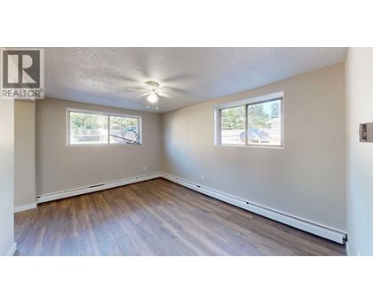 A room with a window and a wooden floor.