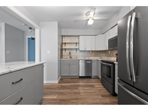 A kitchen with a refrigerator on the right side.
