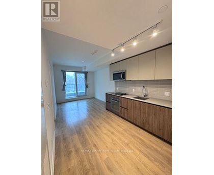 A kitchen with wooden floors and a microwave above the stove.
