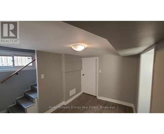 A room with a white door and a staircase with a wooden handrail.