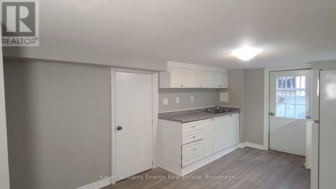 A kitchen with white cabinets and a grey countertop.