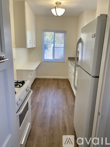 A kitchen with a white fridge and stove top oven.