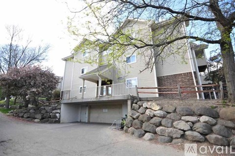 A two-story building with a stone wall in front.
