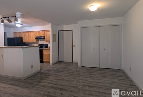 A kitchen area with a black fridge, microwave, and oven, and a white countertop with a cabinet.