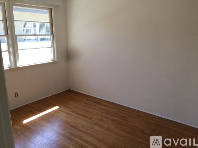 A room with wooden flooring and a window letting in light.