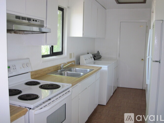A kitchen with white cabinets and a stove top oven.