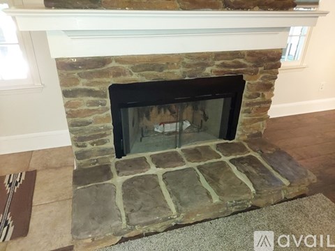 A stone fireplace with a fire burning inside.
