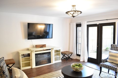 A living room with a television, a chair, and a table.