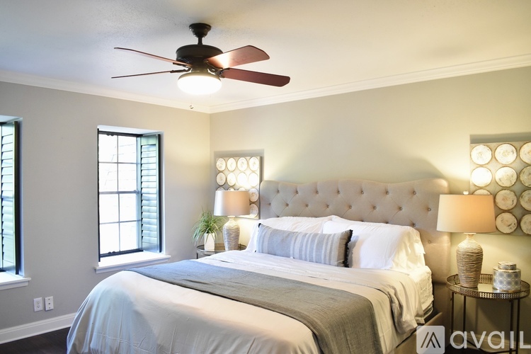 A bedroom with a large bed and a ceiling fan.