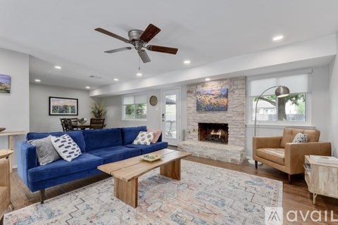 A living room with a blue couch and a fireplace.