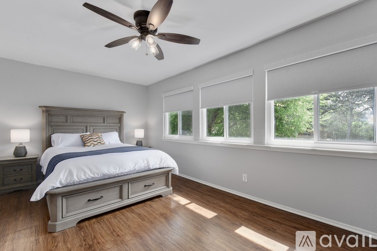 A bedroom with a large bed and a ceiling fan.