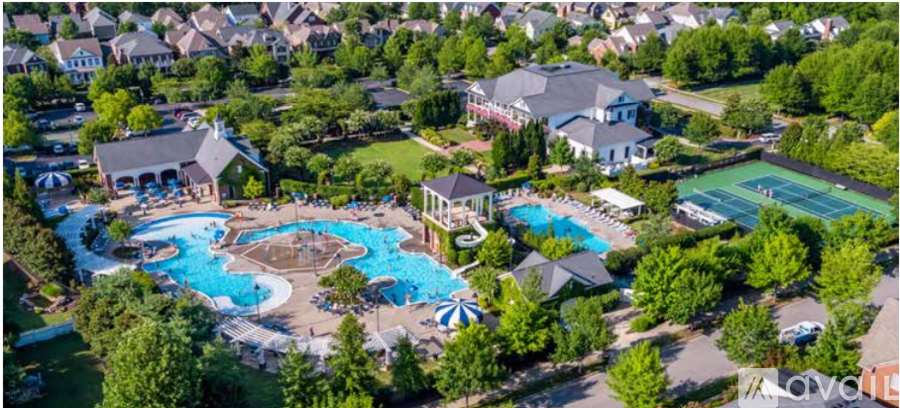 An aerial view of a resort with a swimming pool and tennis court.