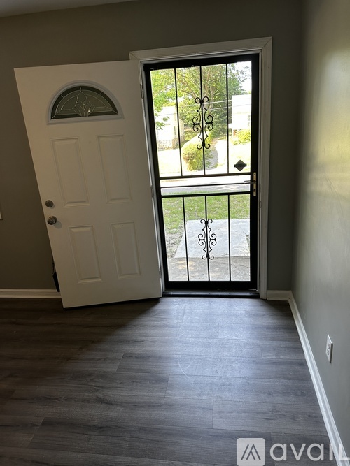 A white door with a glass window is open to a balcony.