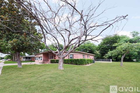A house with a leafless tree in front of it.