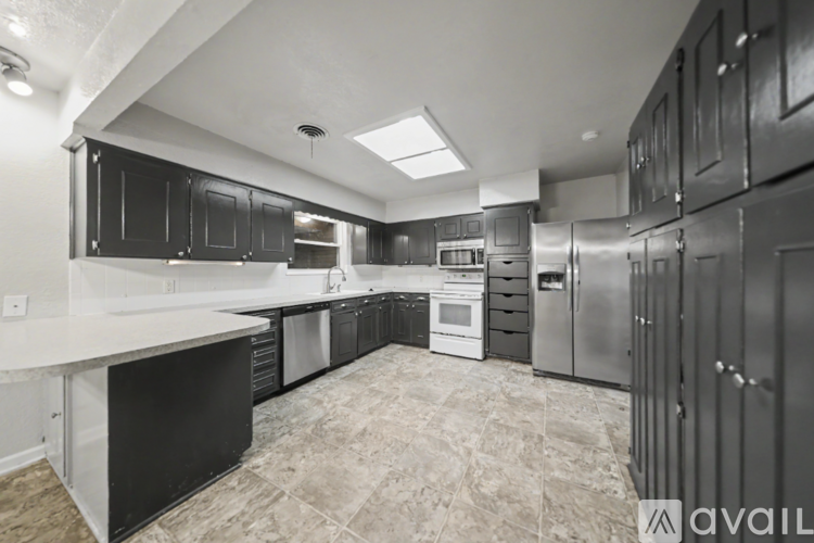 A kitchen with black cabinets and stainless steel appliances.