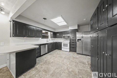 A kitchen with black cabinets and stainless steel appliances.