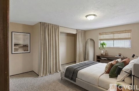 A bedroom with a large bed and a painting on the wall.