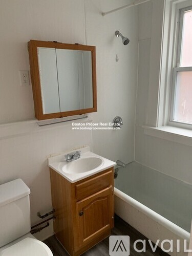 A bathroom with a sink, toilet and mirror.