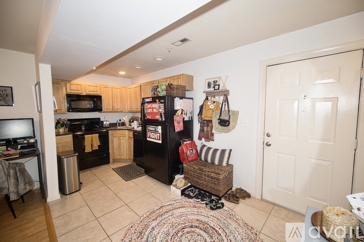 A kitchen with a black fridge and a white door.