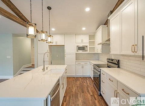A kitchen with white cabinets and a marble countertop.