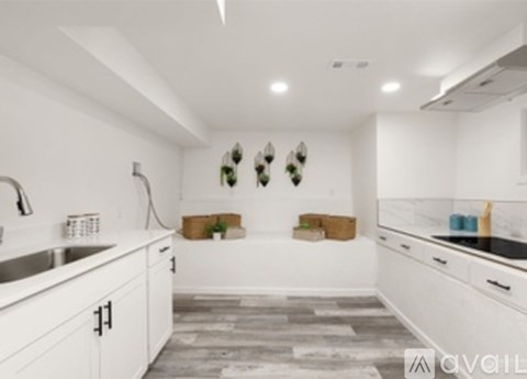 A modern kitchen with white cabinets and a marble countertop.