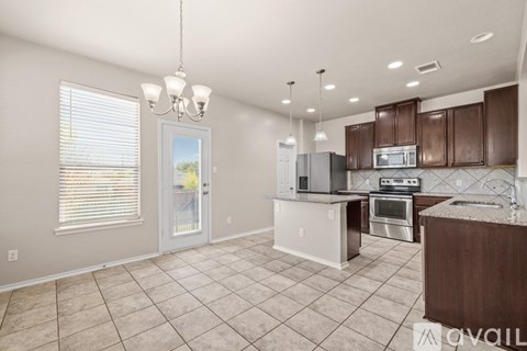 A kitchen with brown cabinets and a white island.