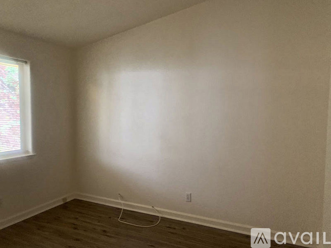 A room with a window and a white wall.