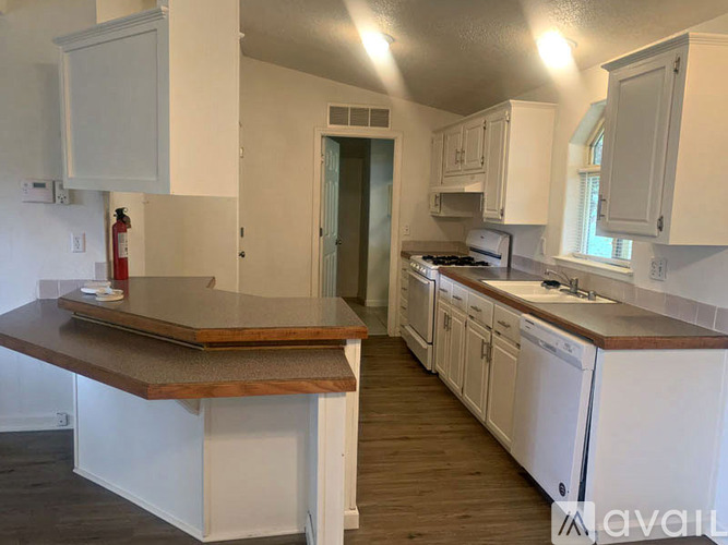 A kitchen with white cabinets and a wooden island.