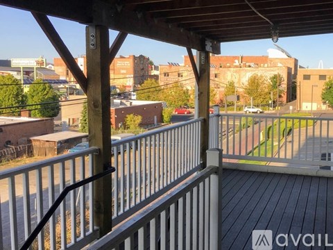 A balcony with a railing and a view of a cityscape.