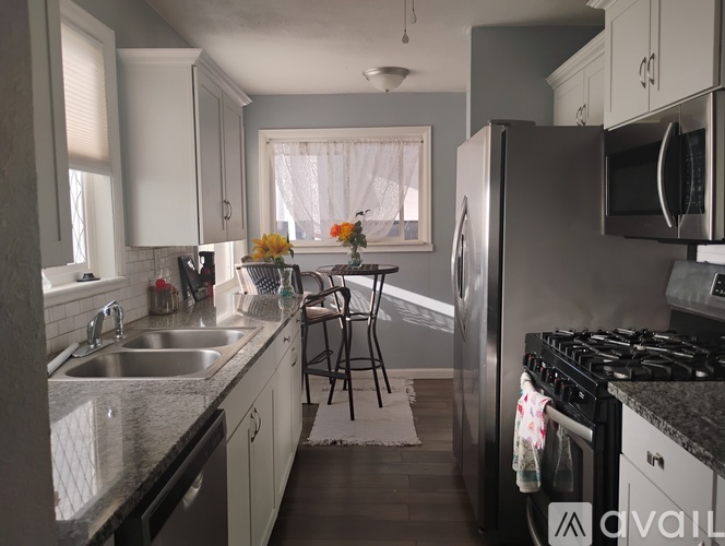 A kitchen with a stove, sink, and refrigerator.