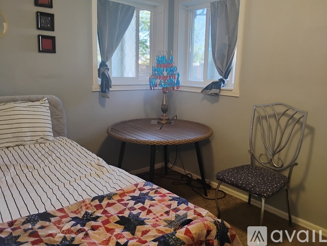 A bedroom with a bed, a round table, and a chair.